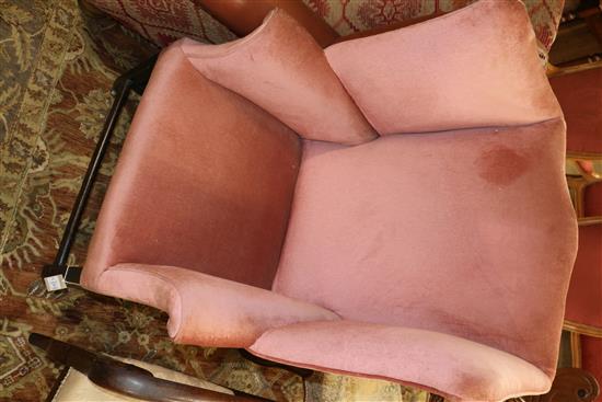 A George III mahogany framed pink dralon upholstered wing armchair